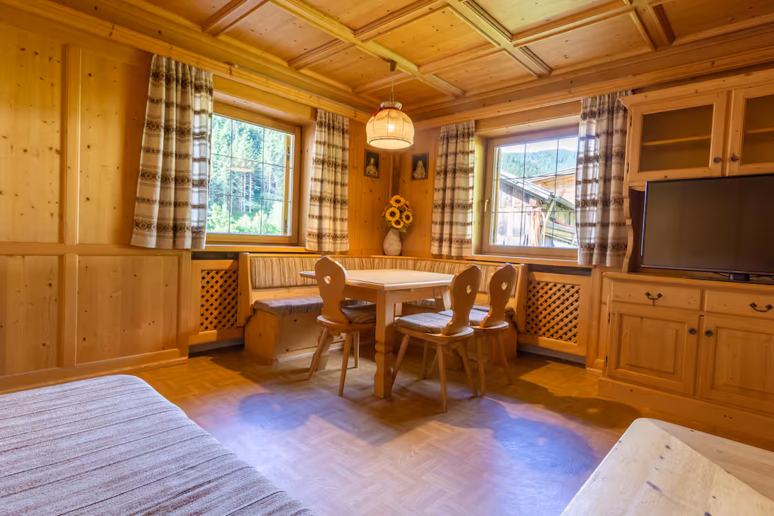 Getäfelte Tiroler Stube mit Eckbank, Holzdecke und Kachelofen